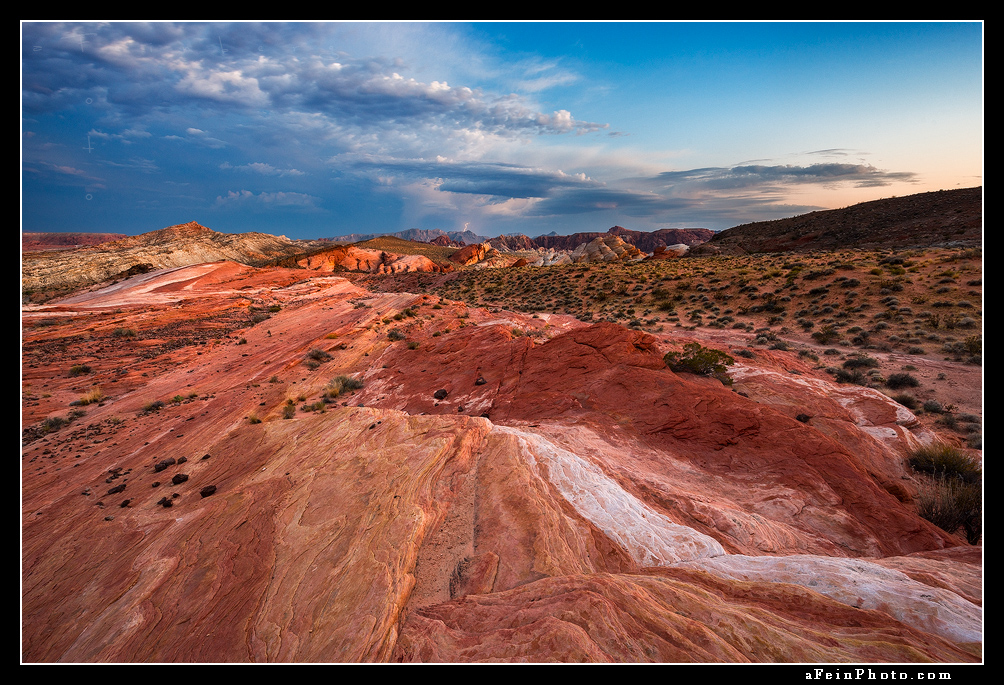 Distant lightning over colorful striated rock in Valley Of Fire, Nevada.