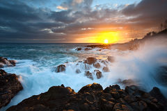 ocean views of waves crashing over rocks at sunset in Poipu, Kauai, Hawaii