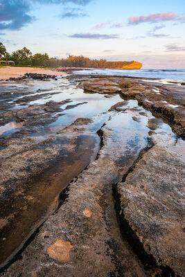Kauai coast with unique rock at sunset on Shipwrecks Beach in Poipu, Kauai, Hawaii 