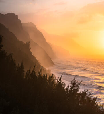 Kauai coastal photography at sunset with backlit sea spray and ocean views along Na Pali Coast, Kauai, Hawaii