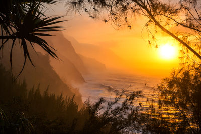 A misty Na Pali Coast mountain silhouettes sunset Kaua'i, Hawai'i