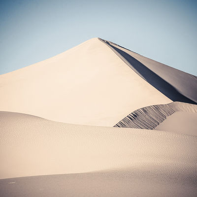 Abstract intersecting dune lines captured in square at Ibex Dunes in Death Valley National Park, California