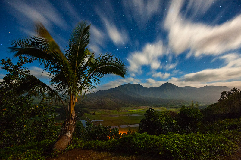 3/4 full moon illuminates Hanalei Valley as the clouds stream out of the south. The rare combination of fast moving clouds from...