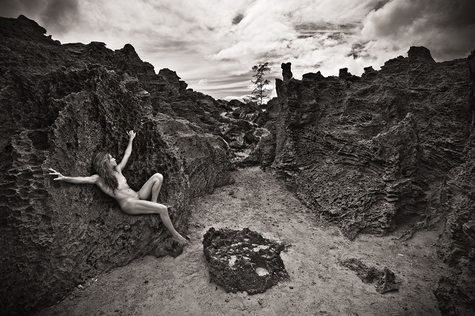 black and white fine art landscape nude against rock formation in Maha'ulepu, Kauai, Hawaii