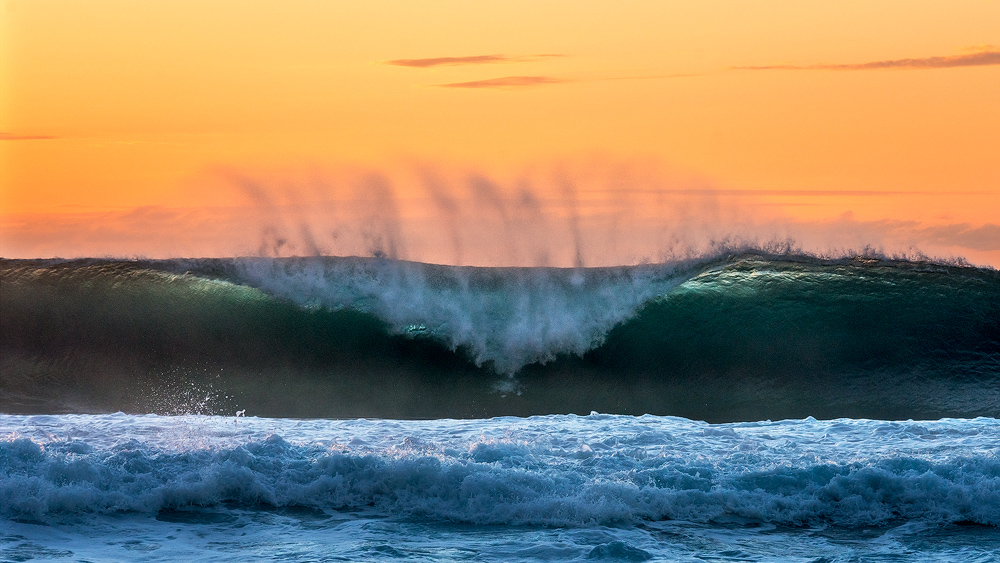 Ocean photography capturing Hawaiian wave crashing at sunset at Ke'e Beach, Kauai, Hawaii