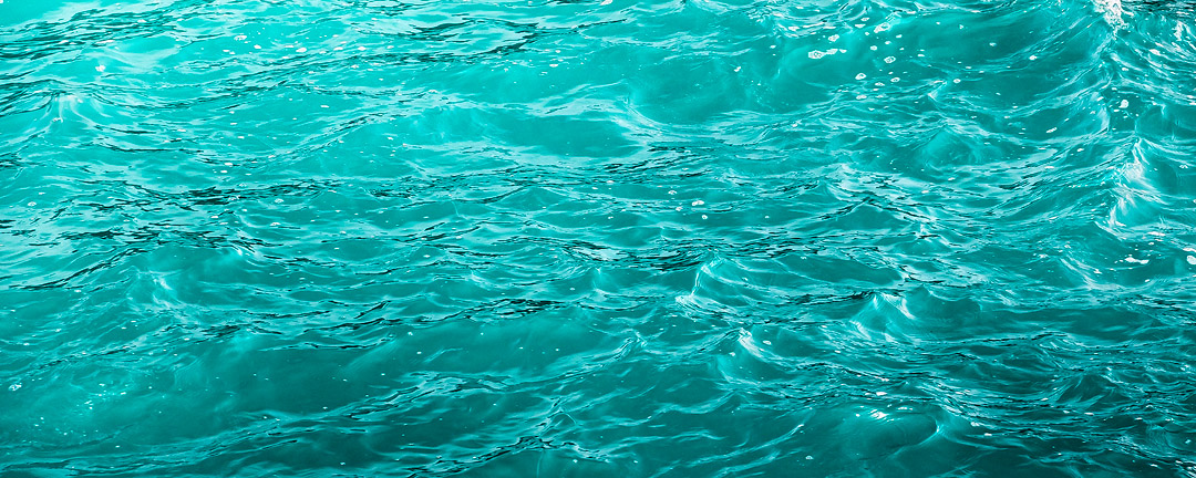 Abstract of turquoise ocean water with subtle ripples.